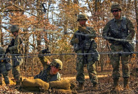 Spc. Morgan Shaffer, combat medic for Headquarters Support Company, Headquarters and Headquarters Battalion, 101st Airborne Division (Air Assault), throws a grappling hook to simulate checking for landmines, Nov. 20, during Expert Field Medic Badge combat training lane familiarization at Fort Campbell. (Spc. Jeremy Lewis, 40th Public Affairs Detachment) 