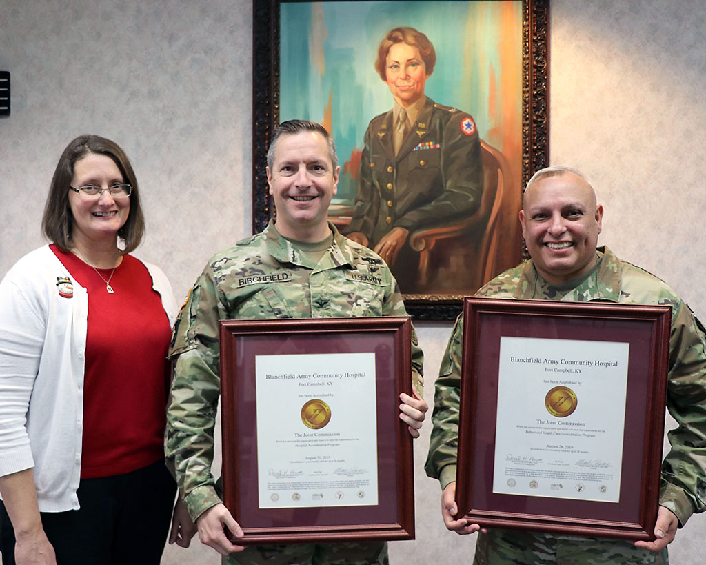 BACH Accreditation Manager, Ms. Quetta Beck, Hospital Commander, Col. Patrick T. Birchfield, and Hospital Command Sergeant Major, Command Sgt. Maj. Daniel Santiago, proudly display the hospital's Gold Seals of Approval from The Joint Commission. The Joint Commission accredits and certifies more than 22,000 health care organizations and programs in the United States. (U.S. Army photo by Maria Yager)
