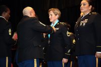 BACH Command Sgt. Major Daniel Santiago places a Sergeant Audie Murphy Club medallion on SAMC inductee Sgt. 1st Class Moriah Mattingly, the hospital’s operations NCOIC. Mattingly and three other Soldiers were inducted into the SAMC during a combined SAMC and NCO Induction Ceremony, January 24 on Fort Campbell, Kentucky. (US Army photo by David Gillespie)