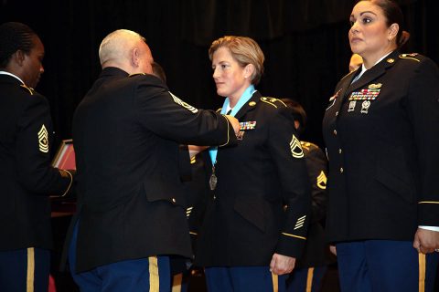 BACH Command Sgt. Major Daniel Santiago places a Sergeant Audie Murphy Club medallion on SAMC inductee Sgt. 1st Class Moriah Mattingly, the hospital's operations NCOIC. Mattingly and three other Soldiers were inducted into the SAMC during a combined SAMC and NCO Induction Ceremony, January 24 on Fort Campbell, Kentucky. (US Army photo by David Gillespie)