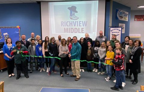 Pictured Back Row (L to R) - Carlye Sommers, Jim Durrett, Bill Harpel, Melinda Shepard, Millard House, Nicol Greiff, Jim Sumrell, Doug Jones, Gene Fish, Jessica Banker, Amber Heggie and Mary McCray. Front Row (L to R) – Lead Custodian: Cynthia Pittman - Student 1: Khamil Childs - Student 2: Raelyn Frederick- Student 3: Kyleigh Gehosky - Student 4 Jodi Miller - Principal: Lisa Baker - Student 5:Shaniya Davis - Energy Champion: Jason Groppel - Student 6: Emily Bowers - Student 7: Matthew Green- Student 8: Miah Benson - Student 9: Haeden Blackburn - Student 10: Scarlet Pressnell - Student 11: Ella Roberts - Student 12: Bradyn Deering - Student 13: Austin Juszkiewicz. Ribbon Holders/Cutters (L to R): Cynthia Pittman, Lisa Baker, Jason Groppel and Austin Juszkiewicz.