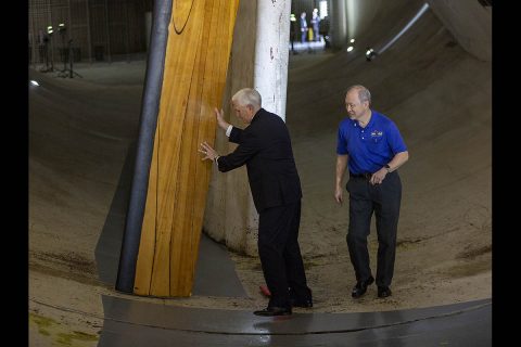 Vice President Mike Pence gives the 14-by 22-Foot Subsonic Tunnel fan blade a push start during a tour stop with Frank Quinto, facility manager of the wind tunnel. (NASA/David C. Bowman)