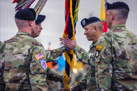 Command Sgt. Maj. Gabelmann, senior enlisted advisor, 1st Brigade Combat Team, 101st Airborne Division (Air Assault) is handed the brigade colors on finale time March 3 during a change of responsibility ceremony in Sabo Physical Fitness Center on Fort Campbell, KY. This will be Gabelmann’s last change of responsibility as he is set to retire later this year bringing 3 decades of service to an end. (U.S. Army photo by Sgt. James Griffin) 