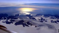 Greenland’s Steenstrup Glacier, with the midmorning sun glinting off the Denmark Strait in the background. The image was taken during a NASA IceBridge airborne survey of the region in 2016. (NASA/Operation IceBridge)