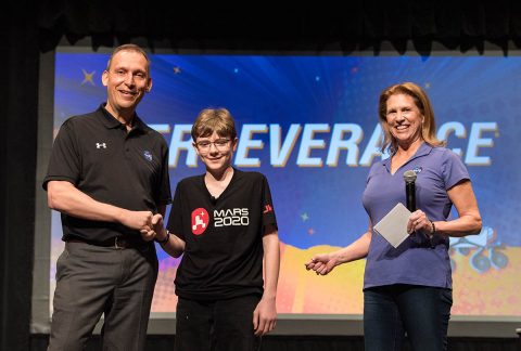 Lori Glaze, director of NASA's Planetary Science Division, looks on as Thomas Zurbuchen, associate administrator of NASA's Science Mission Directorate, congratulates Alexander Mather on March 5, 2020, during a celebration at Lake Braddock Secondary School in Burke, Virginia. The seventh grader had the honor of naming the agency's next Mars rover after submitting the winning entry to the agency's "Name the Rover" essay contest, which received 28,000 entrants from K-12 students from every U.S. state and territory. (NASA)