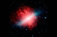 This infrared image from NASA’s Spitzer Space Telescope shows Messier 82, or the “Cigar galaxy,” smothered in smoky dust particles (red) blown out into space by the galaxy’s hot stars (blue). (NASA/JPL-Caltech)