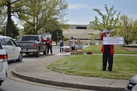 James Moore, supervisory librarian, greets Families as they arrive to pick up bags filled with crafts, April 17 during the Grab-and-Go Brown Paper Bag Craft Giveaway at the Robert F. Sink Memorial Library. Staff from Morale, Welfare and Recreation also gave Families boxes of popcorn. (Emily LaForme, Fort Campbell Courier)