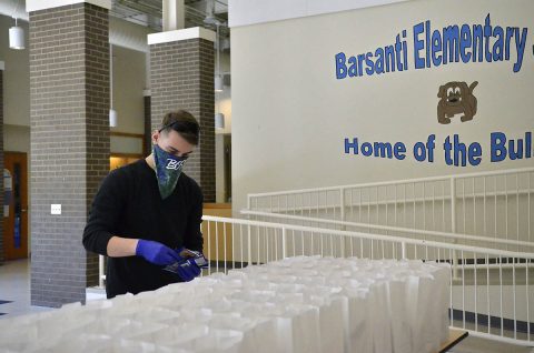 Specialist Matthew Dove, vice president of the Fort Campbell BOSS program, helps package free grab-and-go breakfast and lunch meals for children ages 18 and younger, April 16, at Barsanti Elementary School. The free food distribution is part of the Fort Campbell Child Nutrition Program. (Emily LaForme, Fort Campbell Courier) Specialist Matthew Dove, vice president of the Fort Campbell BOSS program, helps package free grab-and-go breakfast and lunch meals for children ages 18 and younger, April 16, at Barsanti Elementary School. The free food distribution is part of the Fort Campbell Child Nutrition Program. (Emily LaForme, Fort Campbell Courier)