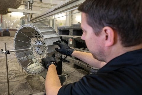 Robotics engineer Jason Schuler performs a preliminary test to prepare for dust testing of various seals for the wheel motors on NASA’s Volatiles Investigating Polar Exploration Rover, or VIPER, March 17, 2020, at NASA's Kennedy Space Center in Florida. The test takes place in a bin holding more than 120 tons of simulated lunar regolith – loose dirt, dust and rock – that is used to help simulate the properties of the lunar surface. (NASA/Cory Huston)