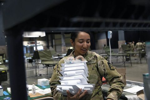 Spc. Ava Leonard, a licensed practical nurse with the 47th combat support hospital, 62nd Medical Brigade on Joint Base Lewis-McChord, WA, gathers medical supplies such as bandages and masks stations at the Army mobilized hospital inside the CenturyLink Events Center in Seattle April 1st, 2020. (U.S. Army photo by Sgt. Erica Earl) 