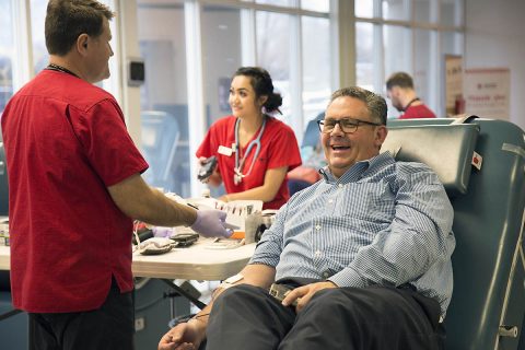 Thomas Brown finishes giving blood with American Red Cross staff member Alex White. (Amanda Romney/American Red Cross)