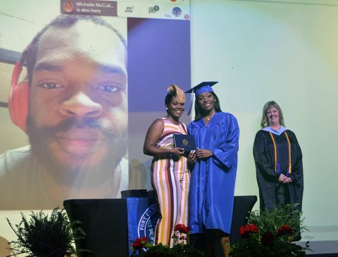 Anijia Black, Fort Campbell High School graduating senior, poses with her mom, Tcipporah Jean-Juste, as FCHS Principal Kimberly Butts looks on during the filming of the FCHS 2020 graduation (Stephanie Ingersoll, Fort Campbell Courier).