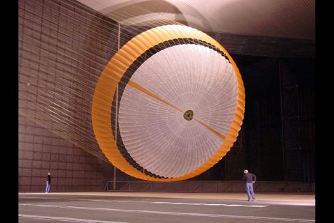 An early parachute design for the Mars Science Laboratory landing system was tested in October 2007 inside the world's largest wind tunnel at the National Full-Scale Aerodynamics Complex. In this image, two engineers are dwarfed by the parachute, which measures more than 165 feet in length and opens to a diameter of nearly 55 feet – with only about 12.5 feet of clearance to both the floor and ceiling. (NASA/JPL/Pioneer Aerospace) An early parachute design for the Mars Science Laboratory landing system was tested in October 2007 inside the world's largest wind tunnel at the National Full-Scale Aerodynamics Complex. In this image, two engineers are dwarfed by the parachute, which measures more than 165 feet in length and opens to a diameter of nearly 55 feet – with only about 12.5 feet of clearance to both the floor and ceiling. (NASA/JPL/Pioneer Aerospace)