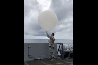 Senior Airman Kyle Boyes of the U.S. Air Force’s 45th Weather Squadron out of Patrick Air Force Base in Florida releases a weather balloon during Underway Recovery Test-8 in the Pacific Ocean in March 2020. (NASA/Amanda Griffin)