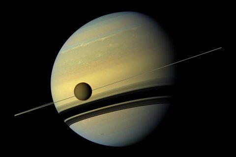 Larger than the planet Mercury, huge moon Titan is seen here as it orbits Saturn. Below Titan are the shadows cast by Saturn's rings. This natural color view was created by combining six images captured by NASA's Cassini spacecraft on May 6, 2012. (NASA/JPL-Caltech/Space Science Institute)