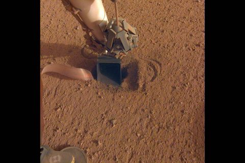 The movement of sand grains in the scoop on the end of NASA InSight's robotic arm suggests that the spacecraft's self-hammering "mole," which is in the soil beneath the scoop, had begun tapping the bottom of the scoop while hammering on June 20, 2020. (NASA/JPL-Caltech)