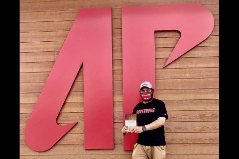 Austin Peay State University professor Somaditya Banerjee poses outside the new Ann R. Ross Bookstore with his book. (APSU)