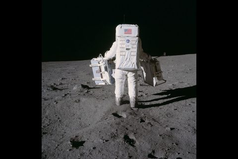 Astronaut Edwin E. Aldrin Jr., lunar module pilot, deploys two components of the Early Apollo Scientific Experiments Package on the surface of the Moon during the Apollo 11 extravehicular activity in 1969. A seismic experiment is in his left hand, and in his right is a laser-reflecting panel. Astronaut Neil A. Armstrong, mission commander, took this photograph. (NASA's Johnson Space Flight Center)