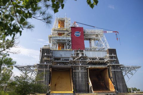 The Space Launch System (SLS) rocket is completing the Green Run test for the rocket’s core stage, shown installed on the top left side of the B-2 Test Stand at NASA’s Stennis Space Center near Bay St. Louis, Mississippi. For Green Run, the team is completing a series of eight tests culminating with Test 8, a full-up hot fire test that lasts eight minutes. Flames from the test will exit out of the yellow flame bucket shown here on the north side of the test stand. (NASA/Stennis) The Space Launch System (SLS) rocket is completing the Green Run test for the rocket’s core stage, shown installed on the top left side of the B-2 Test Stand at NASA’s Stennis Space Center near Bay St. Louis, Mississippi. For Green Run, the team is completing a series of eight tests culminating with Test 8, a full-up hot fire test that lasts eight minutes. Flames from the test will exit out of the yellow flame bucket shown here on the north side of the test stand. (NASA/Stennis)