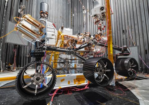 The NASA Ingenuity Mars Helicopter can be seen between the left and center wheels of the Mars 2020 Perseverance rover. The image was taken in the vacuum chamber at JPL on October 1st, 2019. (NASA/JPL-Caltech)