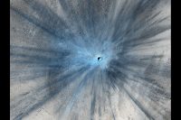 A dramatic, fresh impact crater dominates this image taken by the High Resolution Imaging Science Experiment (HiRISE) camera on NASA’s Mars Reconnaissance Orbiter on Nov. 19, 2013. Researchers used HiRISE to examine this site because the orbiter’s Context Camera had revealed a change in appearance here between observations in July 2010 and May 2012, bracketing the formation of the crater between those observations. (NASA/JPL-Caltech/Univ. of Arizona)