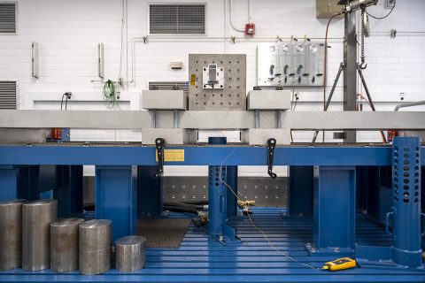 The shock for the test is generated by launching a steel mass (one of the round cylinders in the lower left of the image) into the bottom of the long steel beam. The large clamps set the length of the beam that can “ring” from the impact. By changing the clamp position the profile of the shock can be tuned, hence the name “tunable beam.” The large cube mounted to the beam simplifies mounting of hardware for testing. The shock event is captured using an accelerometer mounted at the hardware. (NASA/JPL-Caltech) The shock for the test is generated by launching a steel mass (one of the round cylinders in the lower left of the image) into the bottom of the long steel beam. The large clamps set the length of the beam that can “ring” from the impact. By changing the clamp position the profile of the shock can be tuned, hence the name “tunable beam.” The large cube mounted to the beam simplifies mounting of hardware for testing. The shock event is captured using an accelerometer mounted at the hardware. (NASA/JPL-Caltech)