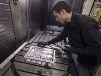 Langley engineer John Savage inspects a section of the navigation Doppler lidar unit after its manufacture from a block of metal. (NASA/David C. Bowman)