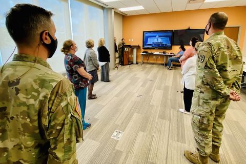 Blanchfield Army Community Hospital Commander Col. Patrick T. Birchfield (left) listens as Army Medicine Chief of Staff and Chief of the Army Medical Department Civilian Corps Mr. Richard Beauchemin praises the team of gathered BACH Soldiers and Department of the Army Civilians for their innovative process-improvement initiative to streamline patient access to behavioral health resources within the hospital’s primary care clinics.