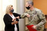 Blanchfield Army Community Hospital Commander Col. Patrick T. Birchfield gives an elbow bump to BACH’s Screaming Eagle Medical Home Behavioral Health Consultant Ms. Joan Lovett before presenting her the Commander’s Certificate of Achievement for her contributions to the behavioral health team. Lovett participated in an award-winning process-improvement initiative to streamline patient access to behavioral health resources within the hospital’s primary care clinics to enhance patient outcomes and medical readiness.