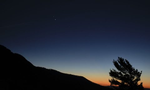 Saturn, top, and Jupiter, below, are seen after sunset from Shenandoah National Park, Sunday, Dec. 13, 2020, in Luray, Virginia. The two planets are drawing closer to each other in the sky as they head towards a “great conjunction” on December 21, where the two giant planets will appear a tenth of a degree apart. (NASA/Bill Ingalls)