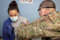 Sgt. 1st Class Daniel Wood, who supports Blanchfield Army Community Hospital’s Soldier Medical Homes, administers the COVID-19 vaccine to registered nurse, Ms. Hillary Justmann. Justmann is a frontline worker who provides medical care to COVID-19 patients admitted to the hospital’s Intensive Care Unit. She and other healthcare workers and first responders are among the first recipients of the first phase of COVID vaccines on Fort Campbell. (U.S. Army photo by David Gillespie)