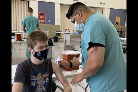 Staff Sgt. Michael Witham, from the Fort Campbell DENTAC, administers a COVID-19 vaccine to military family member Daniel Saucer at the hospital’s COVID-19 vaccine site. After speaking with his parents and doctor, the 17-year old high school student chose to get vaccinated to reduce his chances of contracting the disease and possibly spreading it to others. (U.S. Army photo by Maria Yager)