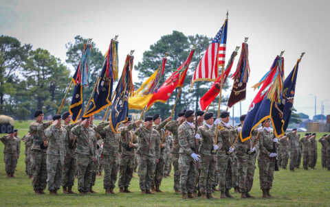 Unit commanders and colour bearers salute during a change of command ceremony for the 3rd Brigade Combat Team, 101st Airborne Division (Air Assault), on Fort Campbell, KY June 18th, 2021. The unit colours is passed during a ceremony which symbolizes the transfer of command responsibility and authority from the old commander to the new commander. (Staff Sgt. Michael Eaddy) 