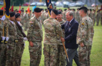 Col. Mark Federovich, incoming commander of the 3rd Brigade Combat Team, 101st Airborne Division (Air Assault), receives the regimental colours from Command Sgt. Maj. (Retired) Gerald Counts, the Honorary Colonel of the 187th Infantry Regiment, during a change of command ceremony on Fort Campbell, KY June 18, 2021. (Staff Sgt. Michael Eaddy)