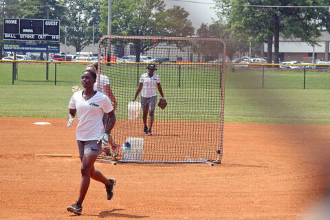 Specialist Nijah McCray, U.S. Army Medical Department Activity, Fort Leonard Wood, Mo., front; and Staff Sgt. Tammy Alexander, E Company, 1-52nd General Support Aviation Battalion, Fort Wainwright, Alaska, behind the screen; field hits July 23 at Fort Campbell. Tryouts started July 22 and will continue through Aug. 2 when coaching staff makes the final cut. (Sirena Clark, Fort Campbell Public Affairs Office)