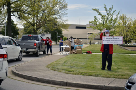 James Moore, supervisory librarian, Directorate of Family and Morale, Welfare and Recreation, greets Families as they arrive to pick up bags filled with crafts, April 17th, 2020, during the Garb-and-Go Brown Bag Craft Giveaway at the Robert F. Sink Memorial Library. (Courtesy Photo, Fort Campbell Public Affairs Office)