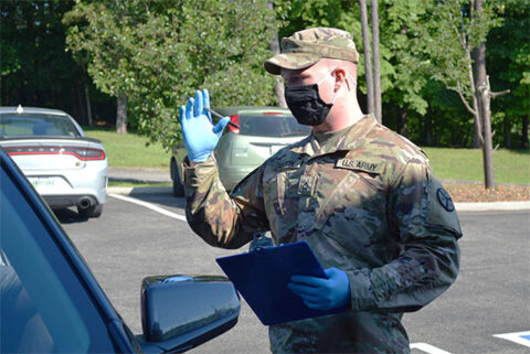 Pfc. William Orton, a cavalry scout assigned to Newport’s O Troop, 4th Squadron, 278th Armored Cavalry Regiment, explains the COVID-19 vaccination process to a resident in Decatur on June 15. Orton has assisted several sites since he joined the COVID-19 Task Force in February. (Sgt. Finis L. Dailey, III)