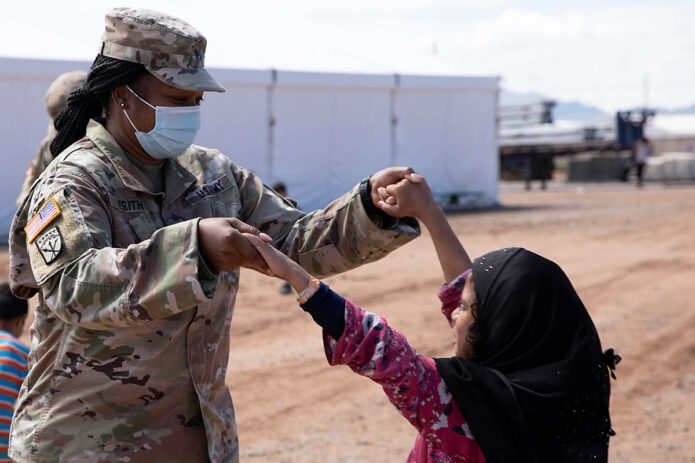 Staff Sgt. Celia Frith with Headquarters and Headquarters Company, 47th Brigade Support Battalion, entertains an Afghan child at Fort Bliss’ Doña Ana Complex in New Mexico, September 2nd, 2021. (Army Pfc. Maxwell Bass)