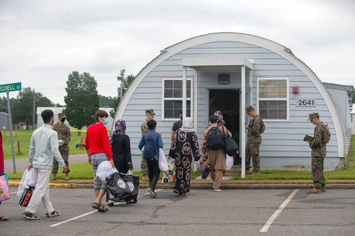 U.S. Marines with Combat Logistics Battalion 2, 2nd Marine Logistics Group, escort Afghans into the living spaces at Marine Corps Base Quantico, Virginia, August 29th, 2021. (Marine Corps Lance Cpl. Scott Jenkins)