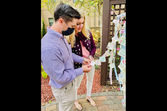 A couple adds the name of their daughter to a Blanchfield Army Community Hospital memorial during last year’s Footprints on Our Hearts observance for families who have lost a baby through miscarriage, ectopic pregnancy, intrauterine fetal demise, stillbirth or infant death. This year’s remembrance ceremony is scheduled for Friday, October 15th at 2:00pm on the lawn outside the hospital’s “A” building. (U.S. Army photo by Maria Yager)