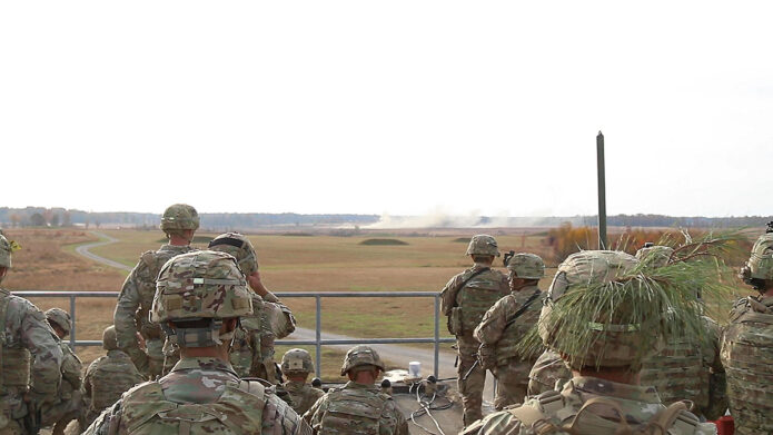 Senior officers and non-commissioned officers observe artillery fires drop onto fighting positions off in the distance from a rooftop as part of the leadership professional development event during Operation Lethal Eagle, November 10th, 2021, Fort Campbell, KY. (U.S. Army Photo by Sfc. Jedhel Somera, 40th Public Affairs Detachment) 