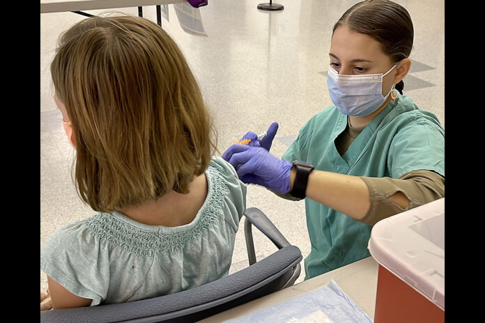 A combat medic specialist administers a Pfizer-BioNTech pediatric COVID-19 vaccine to a nine year-old Military Health System beneficiary at Blanchfield Army Community Hospital’s COVID-19 vaccination site at the Fort Campbell Passenger Processing Center, Nov. 9. The pediatric COVID-19 vaccine for children ages 5 to 11 has the same active ingredients as the vaccine given to adults and adolescents, however children receive an age-appropriate dose that is one-third of the adult dose. (U.S. Army Photo by Maria Yager)