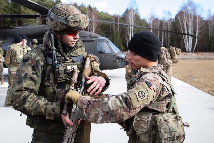 A paratrooper assigned to the Troop B, 5-73 Cavalry, 82nd Airborne Division trains a Polish soldier during a combined training event in Nowa Deba, Poland, Feb. 22, 2022. The 82nd Airborne Division is currently deployed to Poland to train with and operate alongside our Polish allies. The training allows allies to get to know each other’s equipment, capabilities and tactics to enhance readiness and strengthen the NATO alliance. (Army Master Sgt. Alexander Burnett)