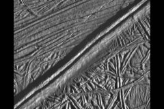 A double ridge cutting across the surface of Europa is seen in this mosaic of two images taken by NASA’s Galileo during the spacecraft’s close flyby on Feb. 20, 1997. Analysis of a similar feature in Greenland suggests shallow liquid water may be ubiquitous across the Jovian moon’s icy shell. (NASA/JPL/ASU)