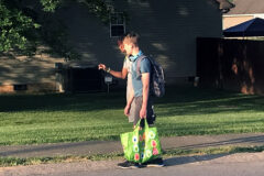 Ethan Steffensmeier carrying a reusable bag to pick up trash along the road.