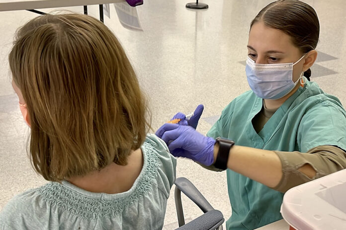 A combat medic specialist administers a Pfizer-BioNTech pediatric COVID-19 vaccine to a nine year-old Military Health System beneficiary at Blanchfield Army Community Hospital’s COVID-19 vaccination site at Fort Campbell. (Maria Christina Yager, Blanchfield Army Community Hospital)