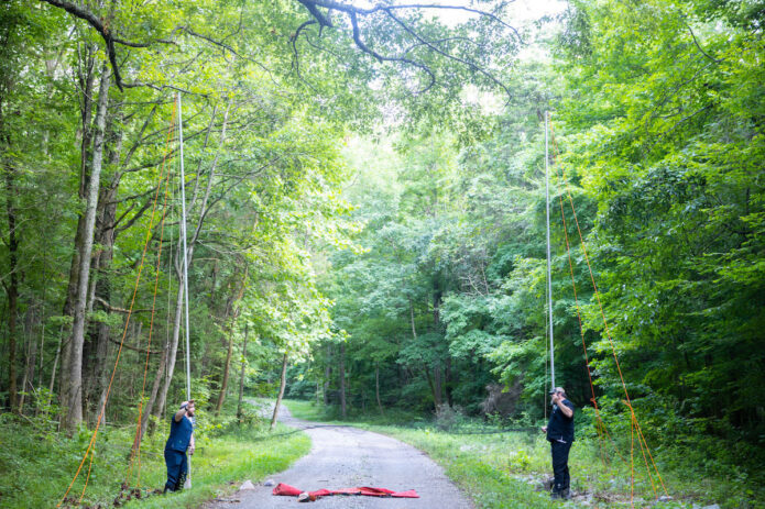 Dakota Van Parys, left, and Brandon Gulley set up a mist net over a Fort Campbell road. (APSU)