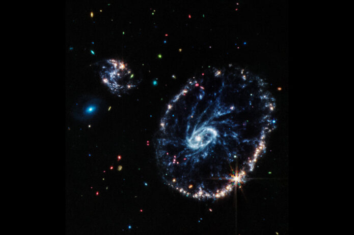 This image from Webb’s Mid-Infrared Instrument (MIRI) shows a group of galaxies, including a large, distorted ring-shaped galaxy, known as the Cartwheel, that is composed of a bright inner ring and an active outer ring. While this outer ring has a lot of star formation, the dusty area in between reveals many stars and star clusters. (NASA, ESA, CSA, STScI, Webb ERO Production Team)