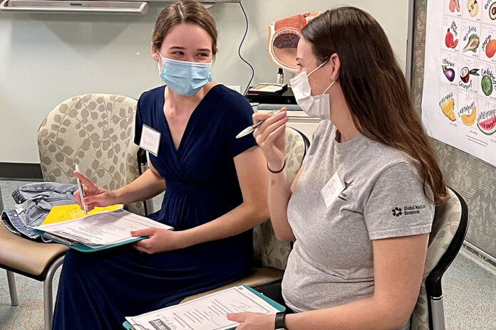 From left, military spouse Hannah Roppolo talks with fellow Centering Pregnancy participant Spc. Jess Biondolino while completing paperwork during their initial centering session Oct. 25 at Blanchfield Army Community Hospital, Fort Campbell, Kentucky. The group-centered prenatal care program includes traditional prenatal care, pregnancy and childbirth education, and provides participants the opportunity to connect with other mothers who have similar due dates. (Maria Tager, Department of Defense)