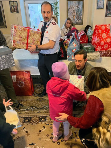 U.S. Army Soldier giving a gift to a Romanian child as part of the Angel Tree project in Constant, Romania, Dec. 22, 2022. (U.S. Army photo by Capt. Clinton Cochran) 